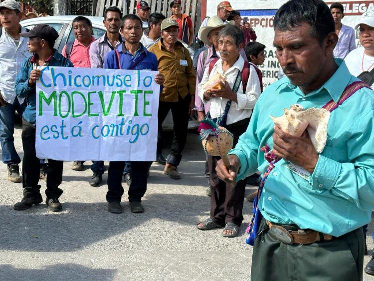 A MODEVITE pilgrimage in November 2023, showing men marching holding conch shells and posters